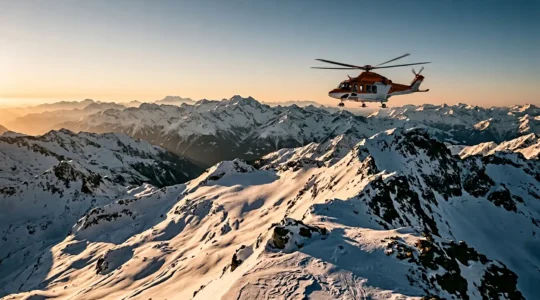 Vue aérienne d'un hélicoptère de secours survolant des sommets enneigés isolés lors d'une mission d'évacuation