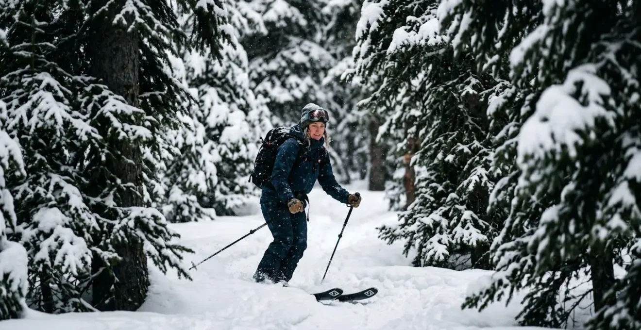 Skieur évoluant dans une forêt de sapins enneigés protégé du vent