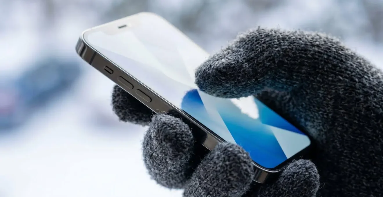 Main tenant un smartphone montrant une attestation d'assurance ski numérisée