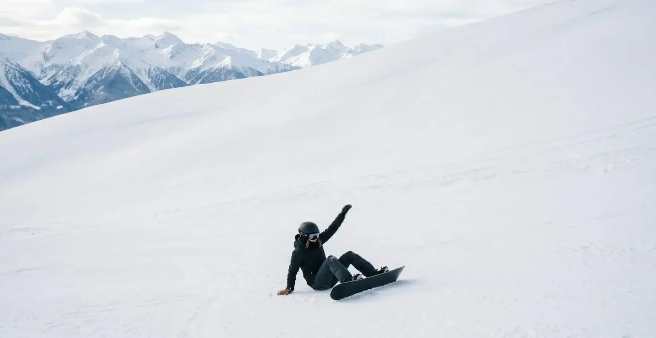 Snowboardeur démontrant la technique du levier pour se relever sur une pente